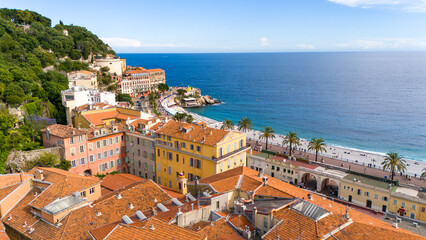 Aerial view of Nice, France, featuring colorful Mediterranean buildings, palm-lined Promenade des Anglais, and the azure waters of the Mediterranean Sea
