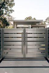 Modern Metal Double Gate with Horizontal Slats, Leading to a Contemporary Home