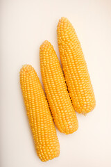 Three peeled ears of corn on a white background. A printed cob. Ripe delicious corn.