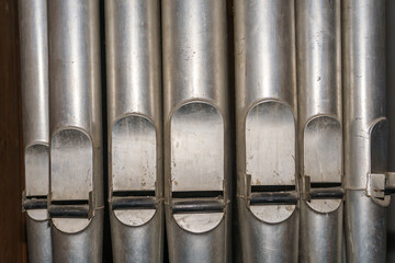 A large classical organ inside the Catholic Church.  A keyboard wind musical instrument. Pipe organ...