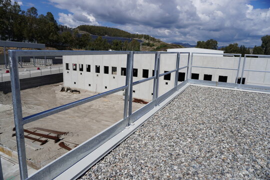 Industrial fence used as a roof parapet. Minimalist design with safety elements. Durability of materials, stability of construction and compliance with safety standards. Corrosion resistance