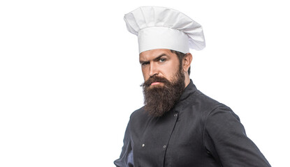 Cooking. Portrait of bearded chef. Bearded male chef in black uniform and a white cap. Serious chef commanding. Serious chef