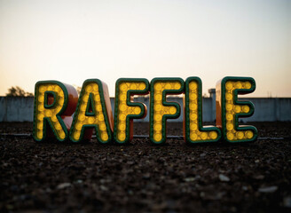 Raffle in yellow light letters on the ground, carnival concept, employee engagement or is it a scam, photo style professional light, sky, wall