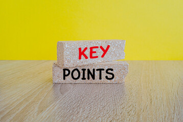 KEY POINTS symbol. Concept words KEY POINTS on brick blocks. Beautiful yellow background, wooden table. Business and technology concept.