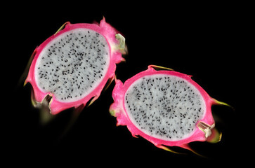 Pitahaya, two halves of the fruit on a black background close-up, detail, freshness, juicy, proper nutrition, vitamins