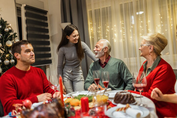 Granddaughter with her grandparents on Christmas Eve. Family having dinner