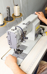 Man showing industrial sewing machine, internal reel management of the machine. Industrial sewing machine structure. Closed angle, close-up.