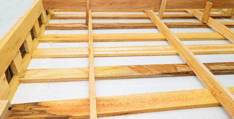 Wooden bed base, pine wood to make a wooden bed. Base to place mattress. Closed angle, close-up.