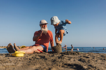 Grandfather and Grandson Playing with Sandcastles