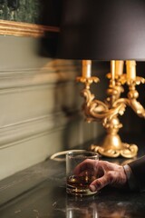 Hand Holding a Whiskey Glass with Ice