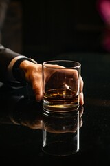 Hand Holding a Whiskey Glass with Ice