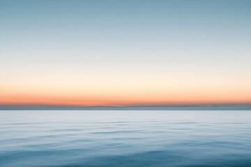 Obraz premium Calm Ocean Surface with a Pink-Orange Sunset Horizon