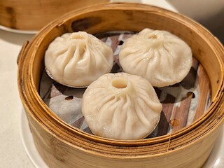 Steamed xiao long bao in bamboo steaming bowl. Chinese steamed bun. Dim sum. Chinese food