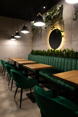 Stylish interior dining area featuring plush green seating and ambient lighting, perfect for a cozy meal in an urban setting