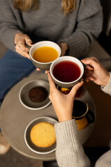Cozy afternoon gathering with friends enjoying tea and sweets in a warm café setting