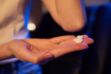 Young woman applying cream on hand against, to dry flaky skin as in the treatment of psoriasis,...