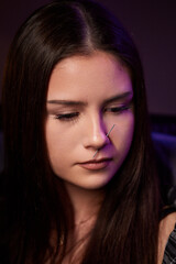 Obraz premium Closeup of a young woman's visage with piercing hanging from her nose.