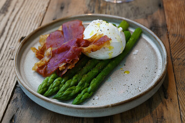 extravagant cuisine, Bacon and eggs on asparagus platter. small plate restaurant food 