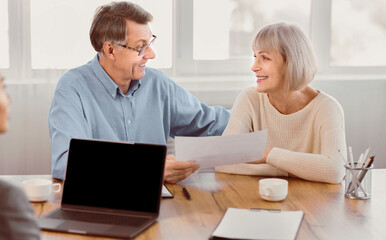 Obraz premium Financial Consultation. Happy elderly couple getting advice from their agent, holding paper, making sale purchase deal