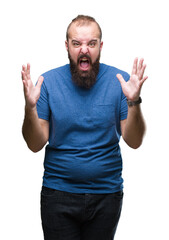 Naklejka premium Young caucasian hipster man over isolated background crazy and mad shouting and yelling with aggressive expression and arms raised. Frustration concept.