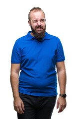 Fototapeta premium Young caucasian hipster man wearing blue shirt over isolated background winking looking at the camera with sexy expression, cheerful and happy face.
