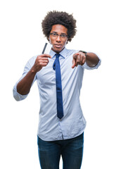 Afro american man holding credit card over isolated background pointing with finger to the camera and to you, hand sign, positive and confident gesture from the front