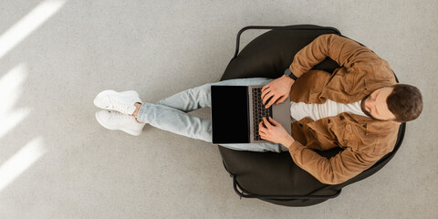 Male Freelancer Using Laptop Computer With Blank Screen Sitting In Chair At Home. Technology And...