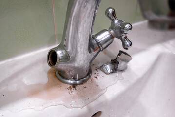 A faucet with dripping water and lime coating in the bathroom.Malfunction of the faucet in the...