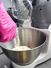 Mixer in the kitchen at home. Equipment for making cream. Professional mixer is on the table. Mixer whips cream. Pastry tools. Making a cake