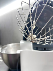 Mixer in the kitchen at home. Equipment for making cream. Professional mixer is on the table. Mixer whips cream. Pastry tools. Making a cake