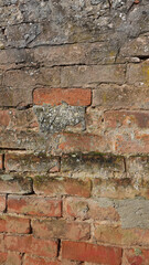 Texture and Colors of an Aged Brick Wall With Moss and Weathered Stones