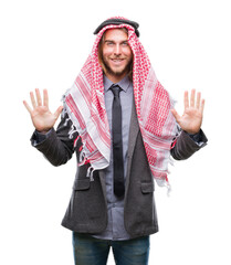 Young handsome arabian man with long hair wearing keffiyeh over isolated background showing and pointing up with fingers number ten while smiling confident and happy.