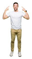 Handsome man wearing casual white t-shirt Smiling pointing to head with both hands finger, great idea or thought, good memory