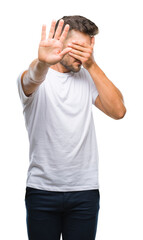 Fototapeta premium Young handsome man over isolated background covering eyes with hands and doing stop gesture with sad and fear expression. Embarrassed and negative concept.
