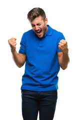 Fototapeta premium Young handsome man over isolated background very happy and excited doing winner gesture with arms raised, smiling and screaming for success. Celebration concept.