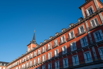 Facade of Plaza Mayor building in Madrid with bright blue sky