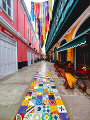 Una colorida calle adoquinada con edificios de colores brillantes a cada lado.  Monumental Callao,...