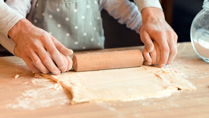 Father Helping To His Little Daughter Roll The Dough On Kitchen Table While They Baking Pastry Together, Cropped Image, Closeup