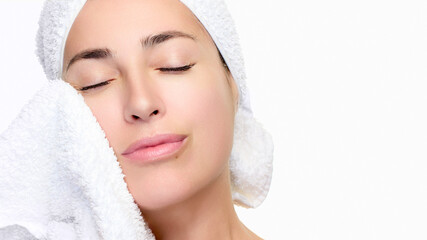 Woman enjoying skincare routine with towel on face