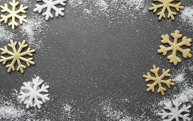 Decorative snowflakes arranged on a dark background with a sprinkle of white sugar resembling snow, perfect for winter festivities