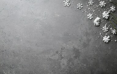 Delicate snowflakes and frost decorations arranged on a textured gray surface during winter festivities