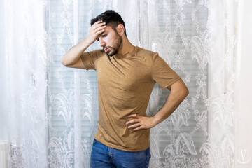 Man with hand on head expressing frustration on white background