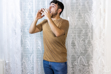 man about to sneeze with hands raised