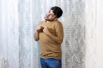 Obraz premium Man pointing at himself with an embarrassed expression on white background