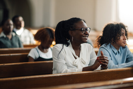 Woman attending sunday church service smiling sitting in pew