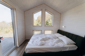 Minimalist cozy bedroom with natural light, modern interior design, and large windows 