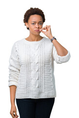 Beautiful young african american woman wearing sweater over isolated background mouth and lips shut...