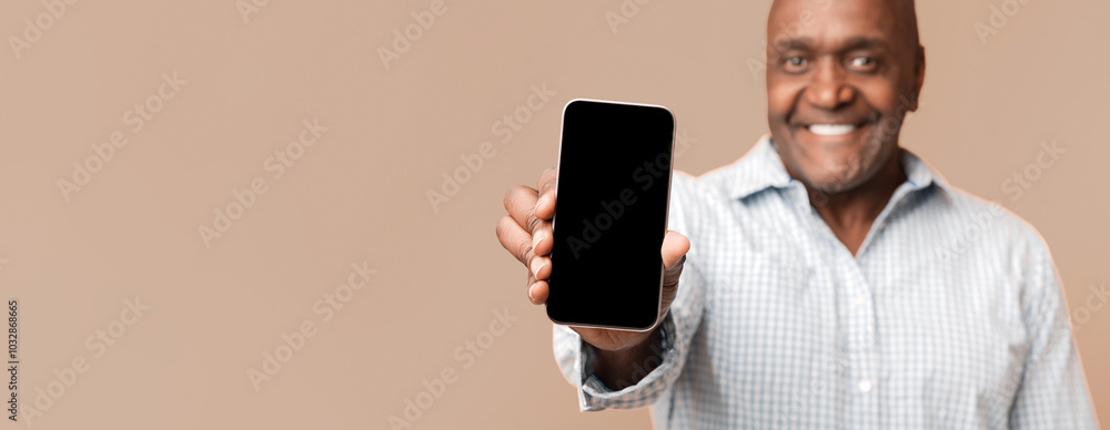 Poster cool mobile application. smiling middle aged afro american man showing cellphone with blank screen