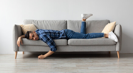 Lack of Energy Concept. Full Body Length Of Exhausted Sleepless Young Man Lying On The Couch With Face Down, Tired In The End Of Hard Working Day, Fatigued Middle Eastern Male Resting At Home