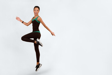 Fitness Workout. Positive Black Girl Jumping Exercising Over Yellow Studio Background. Full Length, Vertical